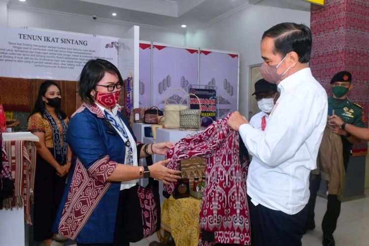 Presiden Jokowi saat membeli jaket bomber dengan motif khas Dayak Sintang, Rabu (08/12/2021), di Sintang, Kalbar.
