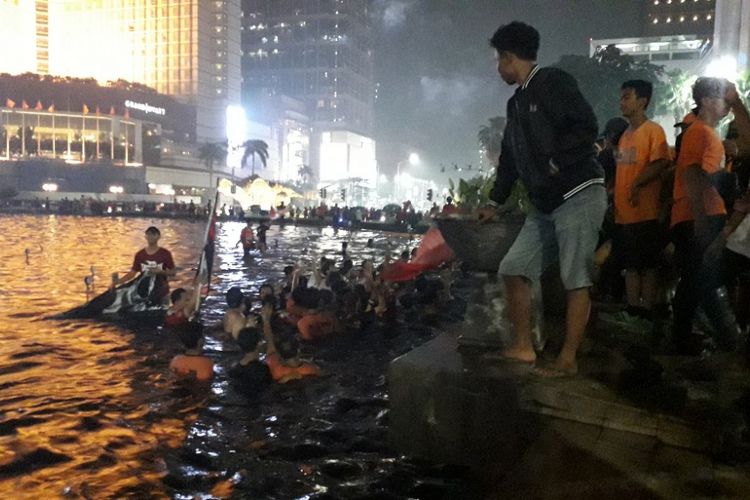 Sejumlah suporter Persija Jakarta menceburkan diri ke kolam Bundaran Hotel Indonesia, Mingu (9/12/2018).