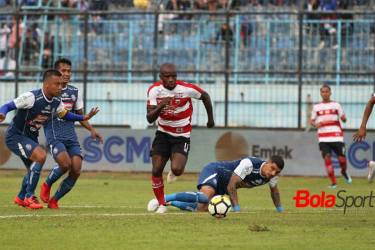 Penyerang Madura United, Greg Nwokolo di antara empat pemain Arema FC: Hamka Hamzah, Hendro Siswanto, Arthur Cunha, dan Alfin Tuasalamony (dari kiri ke kanan) pada lanjutan laga Liga 1 2018 di Stadion Kanjuruhan, Kab Malang pada 17 September 2018.