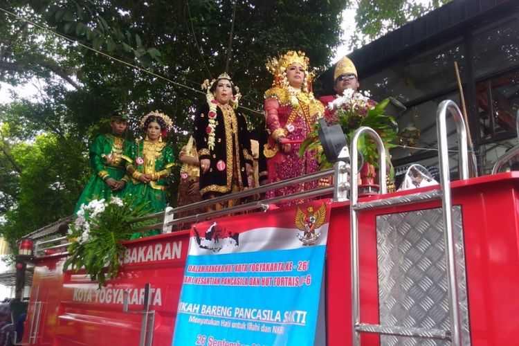 Sejumlah pasangan yang mengikuti nikah massal yang pelaksanaannya dilakukan di atas mobil pemadam kebakaran di pintu keluar DPRD DI Yogyakarta, Jalan Malioboro, Kota Yogyakarta, Selasa (26/9/2017). 