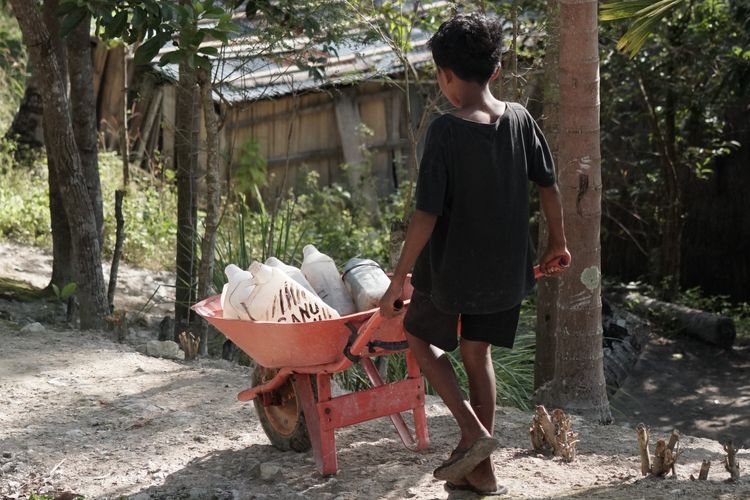 Seorang anak di Desa Basmuti, Kabupaten TTS, NTT membawa pulang jeriken air bersih
