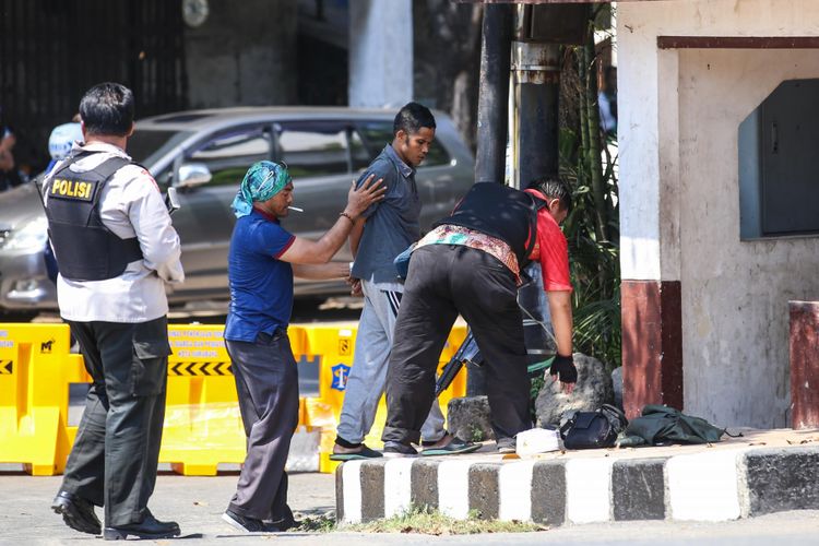Polisi memeriksa seorang warga yang dicurigai membawa tas berisi bom di kawasan Mapolrestabes Surabaya, Jawa Timur, Senin (14/5/2018). - (KOMPAS.com/GARRY ANDREW LOTULUNG)