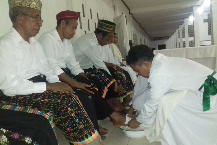 Pastor Eduardus Tanis, Pr sedang membasuh kaki 12 Rasul di Gereja Katolik Paroki Santo Arnoldus dan Josef Waelengga, Kamis, (18/4/2019). Kedua belas rasul yang mendapatkan tugas memakai kain songke dengan tradisi Tengge. Nuansa budaya ditampilkan saat perayaan Paska sekaligus melestarikan budaya tradisi Tengge kain songke di Flores Barat. (KOMPAS.com/MARKUS MAKUR)