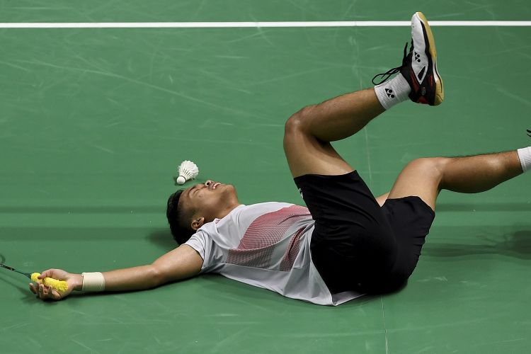 Aksi pebulu tangkis tunggal putra Indonesia Anthony Sinisuka Ginting menjatuhkan diri ke lapangan pertandingan usai menundukkan lawannya pebulu tangkis Jepang Kento Momota pada babak kedua nomor perorangan Asian Games 2018 di Istora Senayan, Jakarta, Sabtu (25/8/2018). - INASGOC