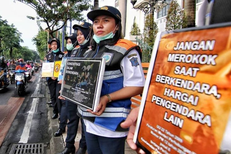 Sejumlah petugas dari Dinas Perhubungan Kota Surabaya melakukan sosialisasi larangan merokok saat berkendara di depan Graha Wismilak, Surabaya, Selasa (9/4/2019).