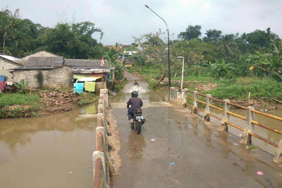 Air Kali Pesanggrahan dan jembatan Pasir Putih Jalan Mawar RT 003 RW 004, Kelurahan Pasir Putih, Kecamatan Sawangan, Depok sudah sejajar dengan air kali, Kamis (15/2/2018).