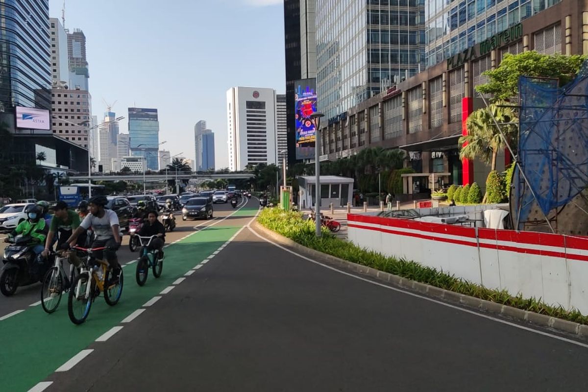 Pesepeda melintasi proyek Tugu Sepeda di Jalan Sudirman, Jakarta Pusat, Jumat (9/4/2021).
