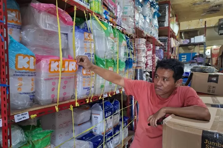 Ronny, pedagang plastik di Pasar Tradisional Panakkukang menunjukkan barang-barang dagangannya berupa kantong plastik dan wadah makanan berbahan plastik yang mengalami kenaikan harga, Kamis (02/04).