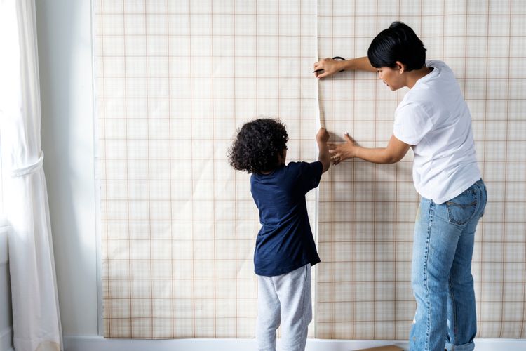 Ilustrasi memasang wallpaper di dinding rumah. 