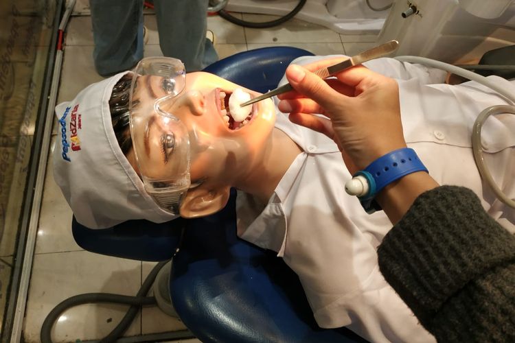 Memperbaiki gigi pasien sebagai dokter gigi di KidZania Jakarta