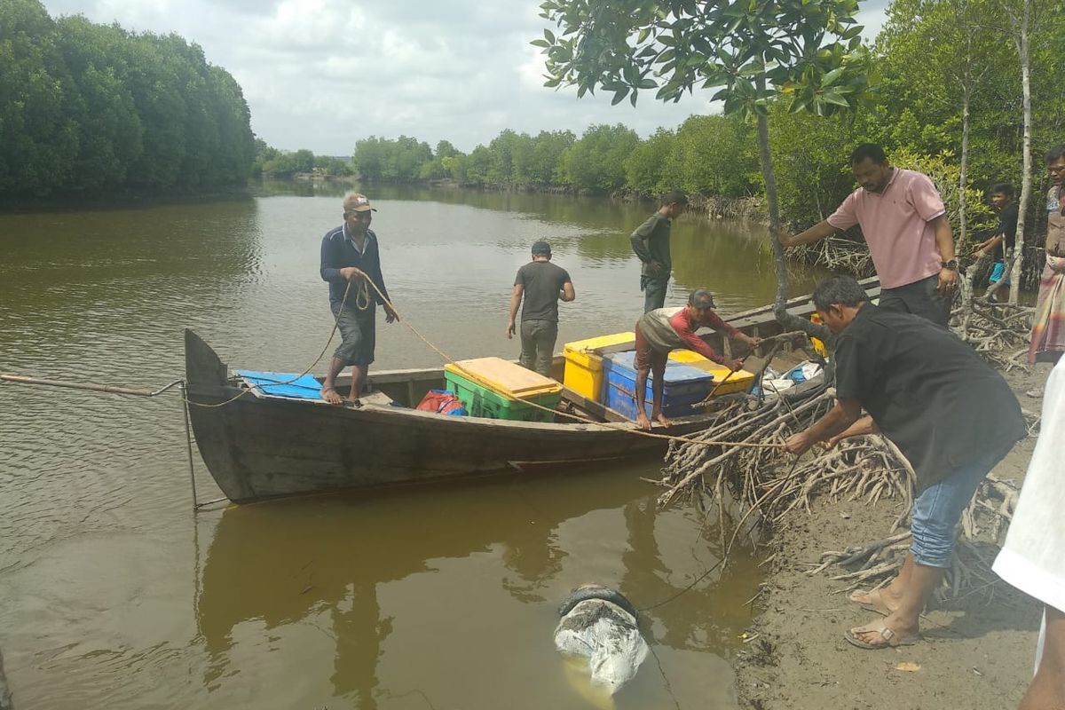Warga mengevakuasi mayat dalam karung di Desa Geulumpang Payung, Kecamatan Sungai Raya, Kabupaten Aceh Timur, Selasa (1/10/2019)