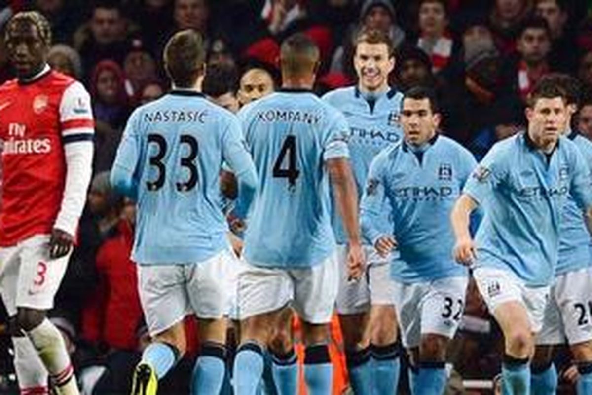 Bintang Manchester City, Edin Dzeko, merayakan golnya bersama rekan-rekannya usai membobol gawang Arsenal, Minggu (13/1/2013). 