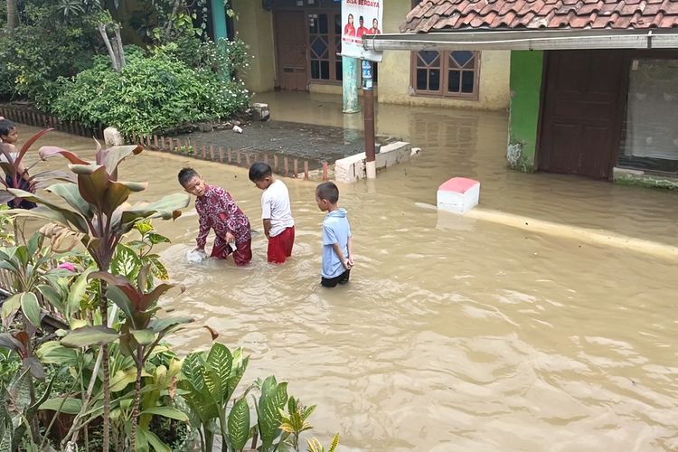 Sejumlah anak-anak tengah melintasi banjir yang melanda Kampung Bojongasih, Desa Dayeuhkolot, Kecamatan Dayeuhkolot, Kabupaten Bandung, Jawa Barat pada Senin (8/1/2024)