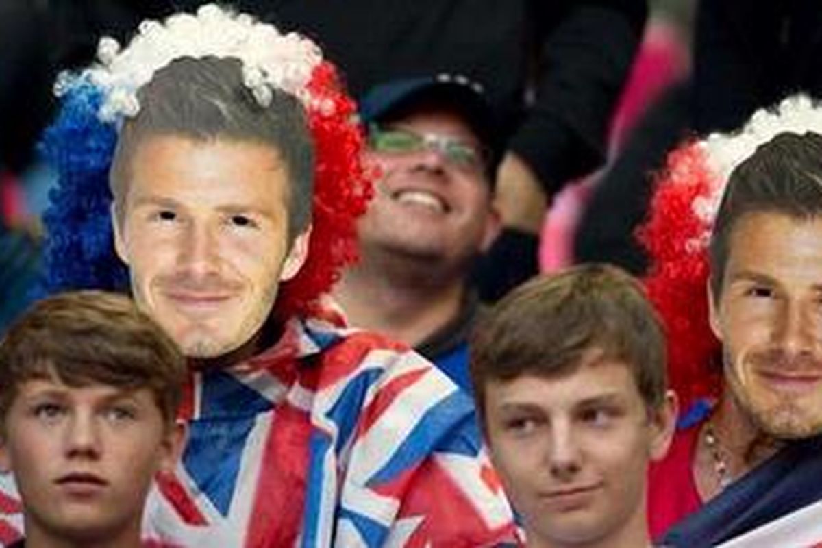 Fans sepak bola Inggris mengenakan topeng David Beckham saat menunggu pertandingan antara Inggris Raya melawan Uni Emirat Arab di babak penyisihan grup Olimpiade London 2012, Minggu (29/7/2012).