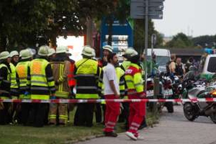 Pasukan pemadam kebakaran siaga di dekat pusat perbelanjaan Olympia Einkaufzentrum OEZ di Munich, Jerman, Jumat (22/7/2016), setelah serangan bersenjata di tempat itu. Sembilan orang dilaporkan tewas. 