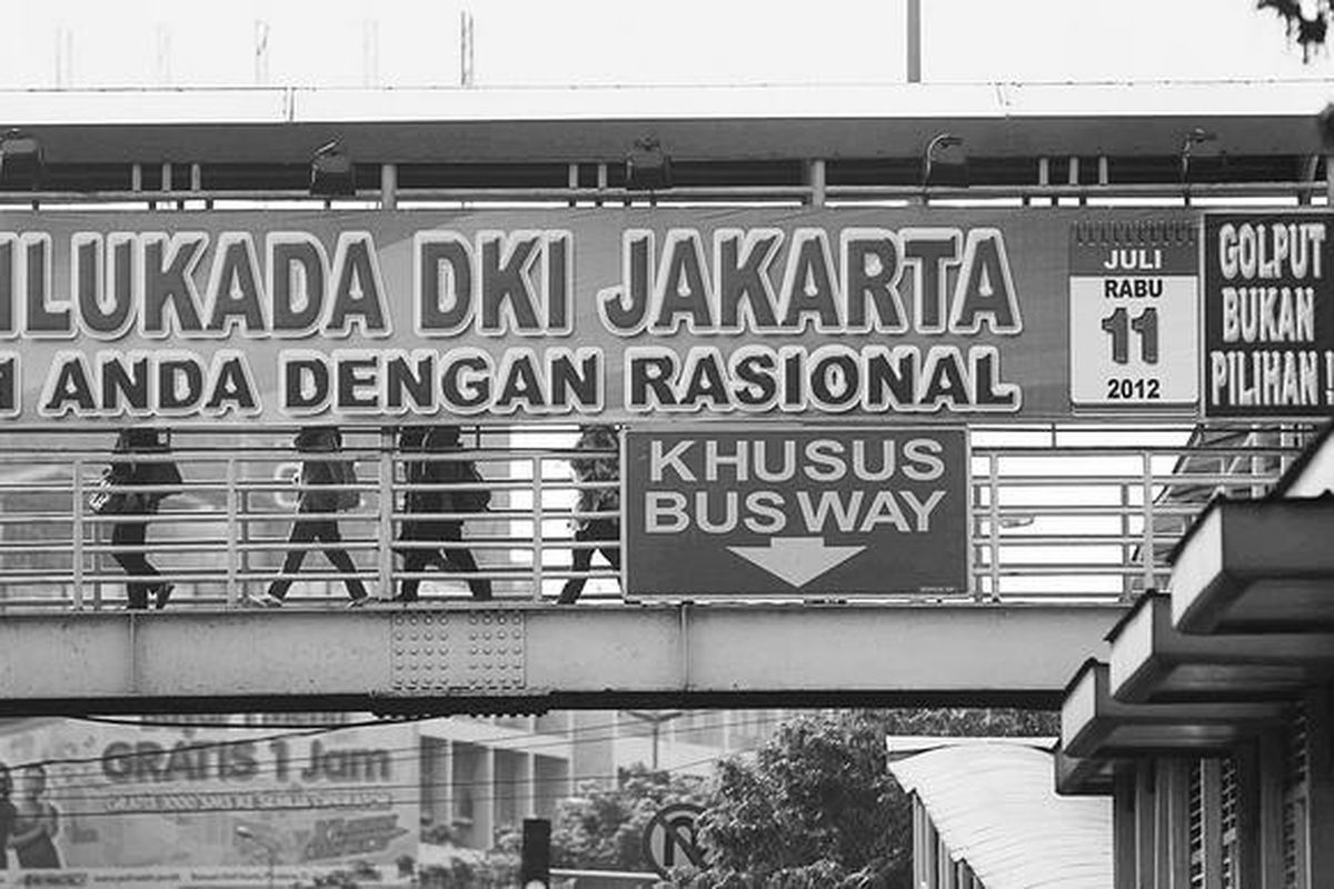 Spanduk imbauan untuk menyukseskan Pilkada DKI Jakarta terpasang di salah satu jembatan penyeberangan di Jalan Kramat Raya, Jakarta Pusat, Selasa (12/6). Warga Jakarta yang mempunyai hak pilih diharapkan berpartisipasi.