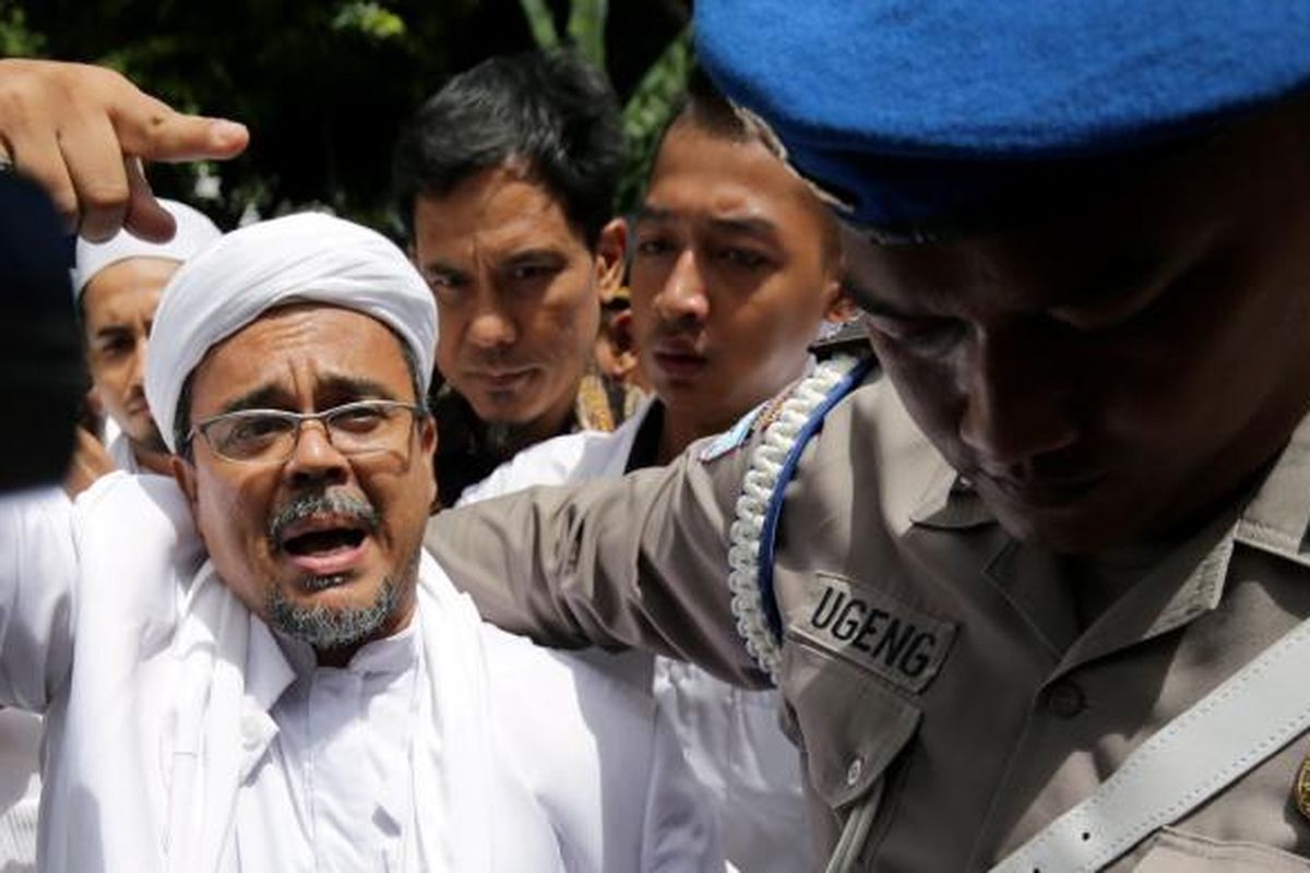 Pimpinan Front Pembela Islam, Rizieq Shihab tiba di Kantor Direktorat Reserse Kriminal Khusus, Polda Metro Jaya, Jakarta, Senin (23/1/2017). Rizieq diperiksa oleh Subdirekorat Fiskal, Moneter, dan Devisa Direktorat Reserse Kriminal Khusus Polda Metro Jaya, terkait ucapannya soal gambar palu arit di logo Bank Indonesia dalam lembaran uang rupiah. KOMPAS IMAGES/KRISTIANTO PURNOMO