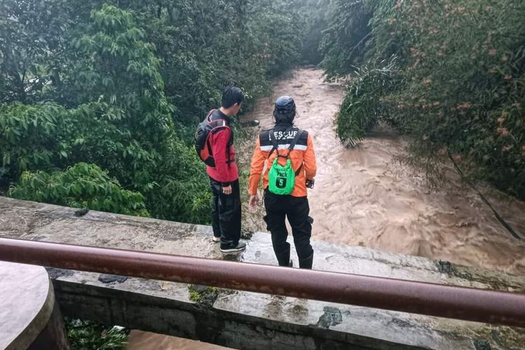 Dua sukarelawan dalam operasi pencarian anak hanyut dengan mengamati arus air di aliran sungai Cigunung, Kecamatan Cisaat, Sukabumi, Jawa Barat, Rabu (12/10/2022).