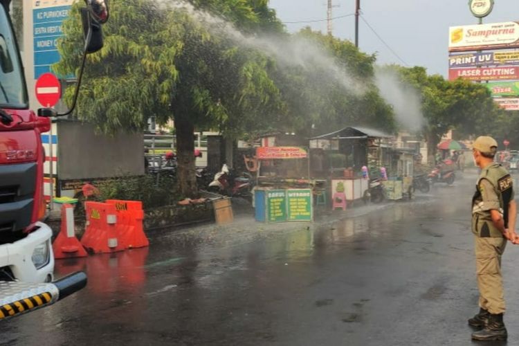 Anggota Satpol PP membubarkan PKL di Alun-alun Purwokertto, Kabupaten Banyumas, Jawa Tengah, dengam cairam disinfektan, Sabtu (5/6/2021).