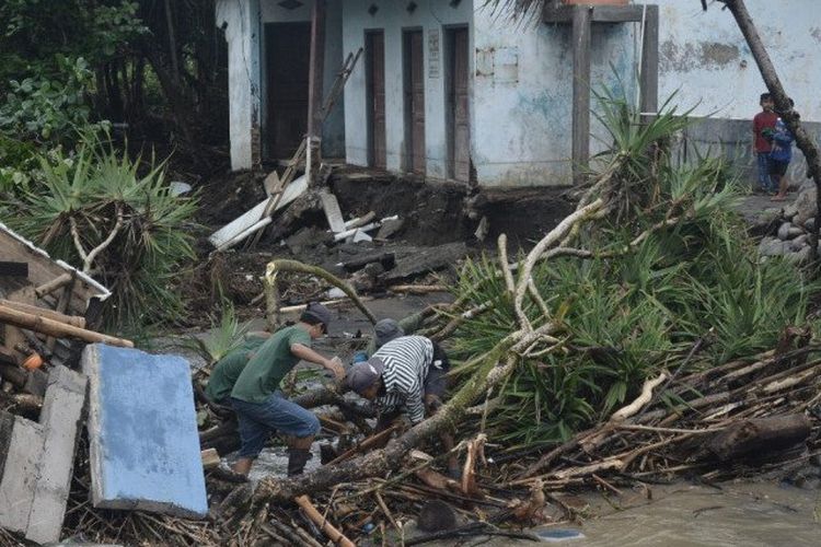 Seorang warga membersihkan material dampak dari bencana banjir bandang di Kecamatan Cibalong, Kabupaten Garut, Jawa Barat, Selasa (13/10/2020). 