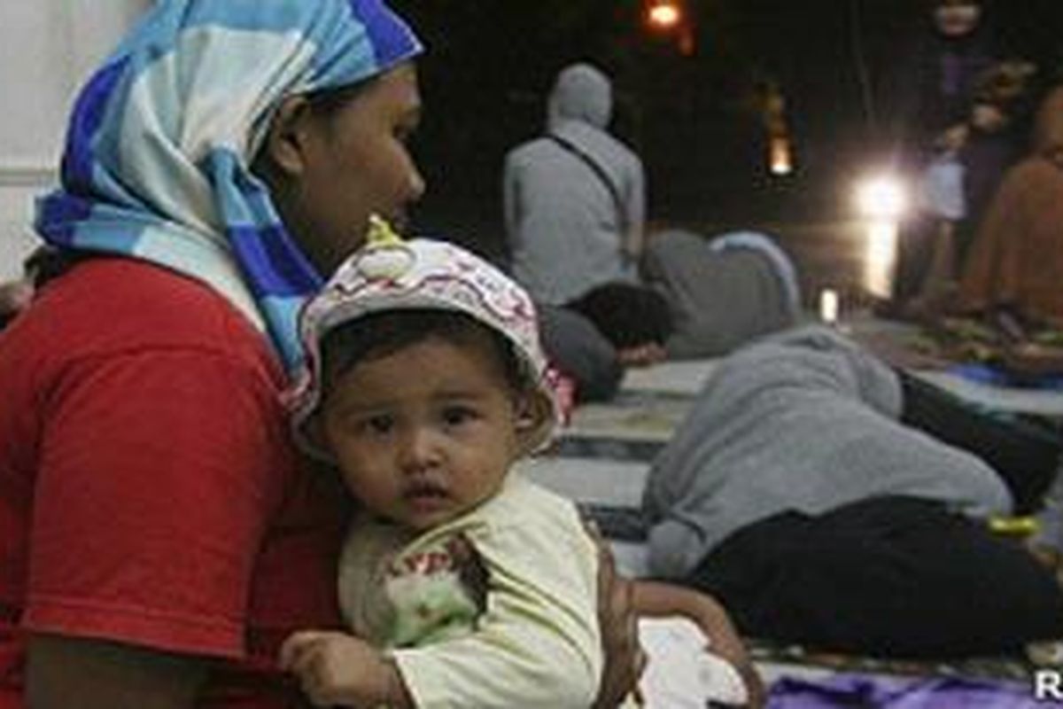 Seorang ibu dan anak balitanya mengungsi pasca gempa bumi di Aceh, Rabu (11/04).