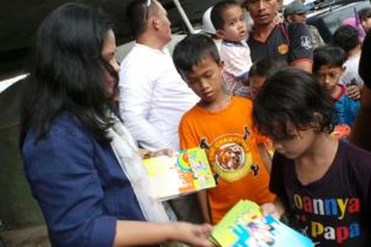 Iriana Joko Widodo membagikan buku kepada anak-anak.
