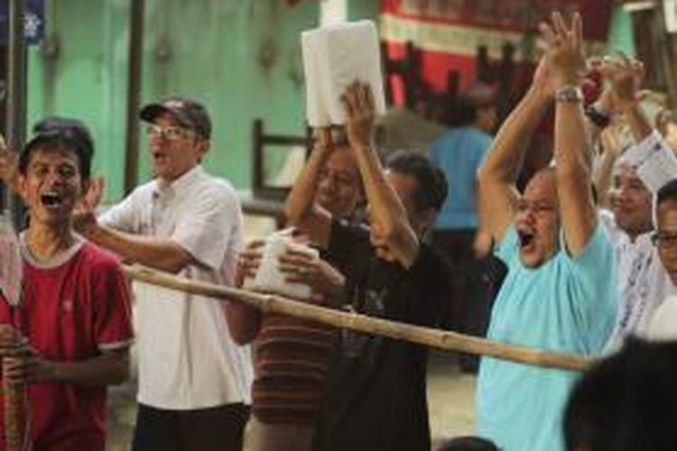 Warga Manggarai, Jakarta Selatan, yang melihat hasil penghitungan suara di TPS 022, bersorak kegirangan setelah capres pilihannya berhasil unggul di TPS tersebut, Rabu (9/7/2014).  