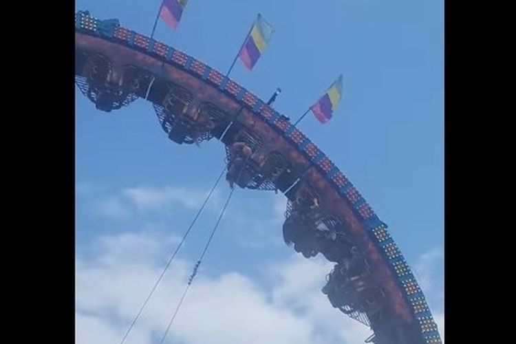 Sebuah roller coaster berhenti bergerak dalam posisi terbalik.