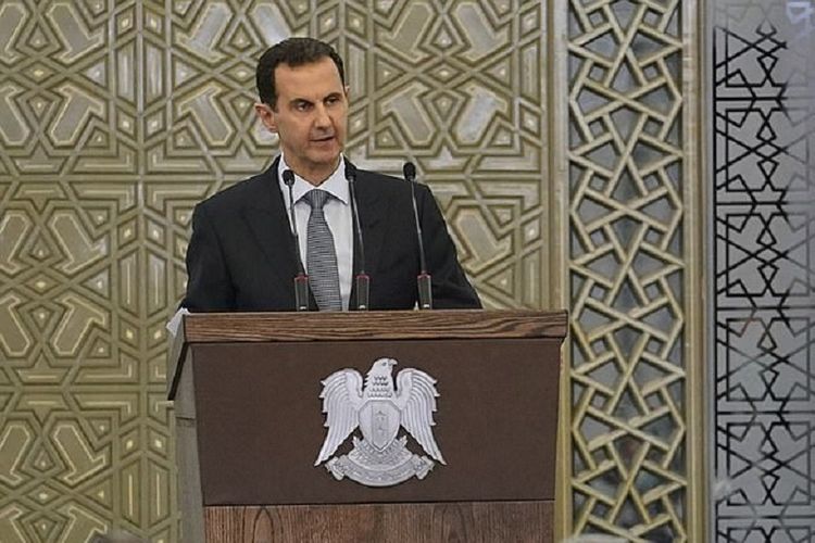 Presiden Suriah Bashar al-Assad berpidato di depan parlemen pada Rab (12/8/2020). Dia harus dua kali melakukan interupsi setelah mengaku tekanan darah rendahnya kambuh.