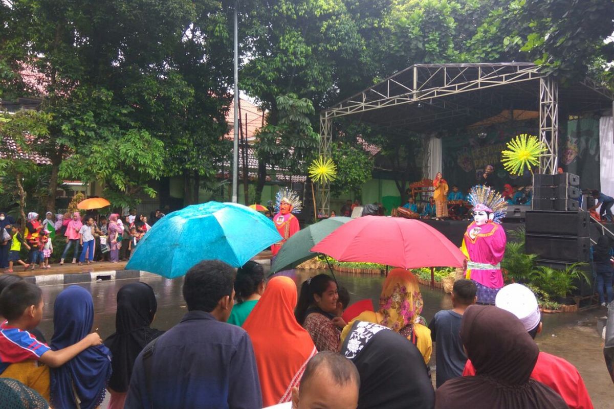 Meski hujan, masyarakat tetap antusias datang ke Festival Bongsang di Jalan Raya Ragunan Jati Padang dengan menggunakan payung, Sabtu (24/3/2018).