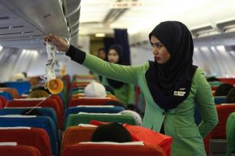Dalam foto bertanggal 22 Desember 2015, seorang pramugari Rayani Air tengah menyiapkan kesiapan kabin sebelum penerbangan dari bandara Sultan Ismail Petra, di Kelantan, Malaysia.