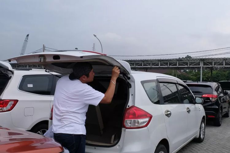 Konsumen mengecek unit mobil yang dilelang