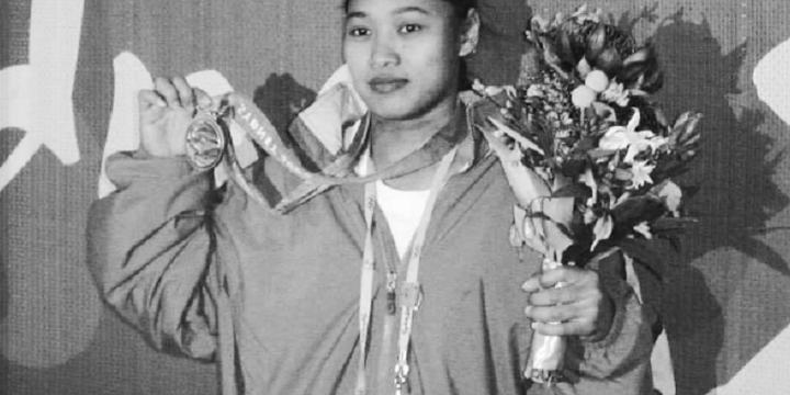 Lifter putri Indonesia, Winarni, berpose di hadapan para wartawan menunjukkan medali perunggu di tangan kanan, dan rangkaian bunga di tangan kiri, setelah upacara pengalungan medali di Sydney pada Senin, (18/9/2000).
