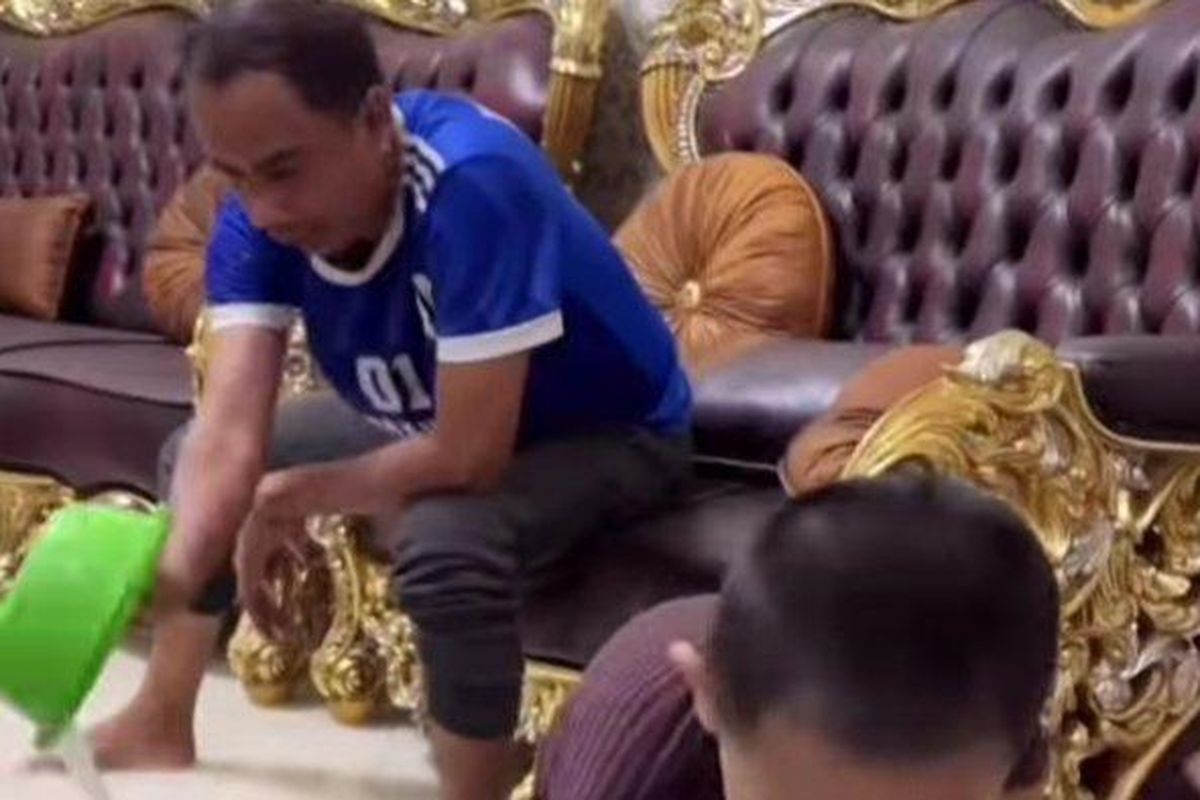 Ketua DPRD Makassar Rudianto Lallo terlihat menguras air yang masuk di rumah jabatannya, Jl Hertasning, Senin (13/2/2023).