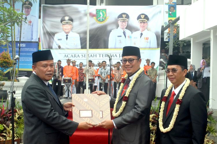 Penjabat Wali Kota Sukabumi Dady Iskandar (kiri) menyerahkan jabatan kepada Wali Kota Sukabumi Achmad Fahmi (tengah) didampingi Wakil Wali Kota Sukabumi Andri Setiawan Hamami (kanan) saat upacara sertijab di Balai Kota Sukabumi, Jawa Barat, Jumat (21/9/2018). 