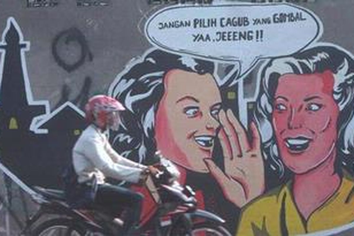 Warga melintas di depan mural ajakan agar memilih calon gubernur yang tidak mengobral janji di salah satu tembok di ajlan Daan Mogot, Jakarta Barat, Selasa (3/7/2012). Ajakan itu juga untuk mengkampanyekan agar warga memilih calon gubernur dengan menggunakan hati.  