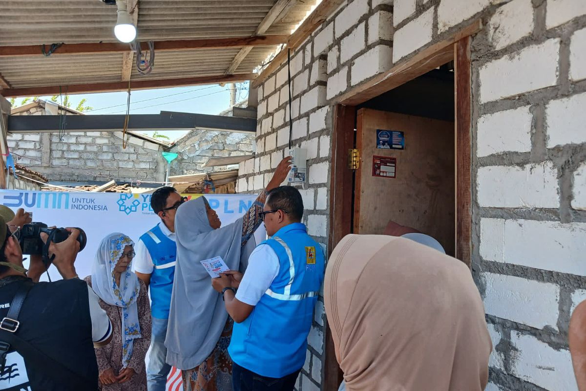 Muawanah dipandu General Manager PLN UID Jawa Timur Agus Kuswardoyo, saat pertama kali memasukkan kode pin token listrik di rumahnya di Desa Kawistowindu, Kecamatan Duduksampeyan, Gresik, Jawa Timur, Kamis (15/8/2024).