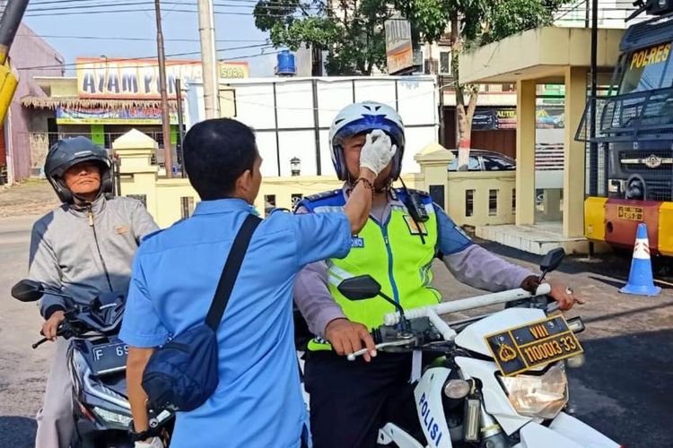 Tim Corona Response Team (CRT) Polres Cianjur memeriksa suhu tubuh seorang anggota polisi yang hendak memasuki mako Polres Cianjur, Jawa Barat, Senin (16/3/2020). Pemeriksaan dilakukan dalam upaya mencegah penyebaran virus Corona atau Covid-19