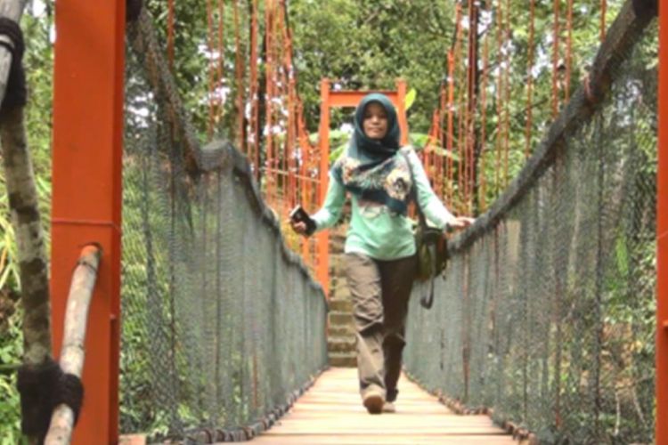 Salah satu pengunjung melintasi jembatan gantung kawasan wisata Banyu Nget, Trenggalek, Jatim yang diberi nama jembatan Kangen.
