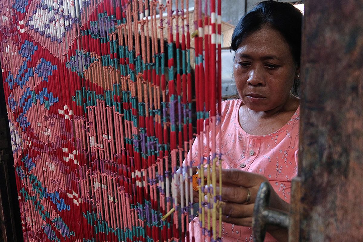 Foto dirilis Rabu (6/5/2020), memperlihatkan perajin kain endek tradisional melakukan proses pewarnaan motif pada benang di Bali. Usaha pertenunan kain endek yang sempat melorot mulai dibangkitkan kembali seiring dengan target pemerintah dalam memajukan sektor UMKM sekaligus upaya pelestarian budaya.