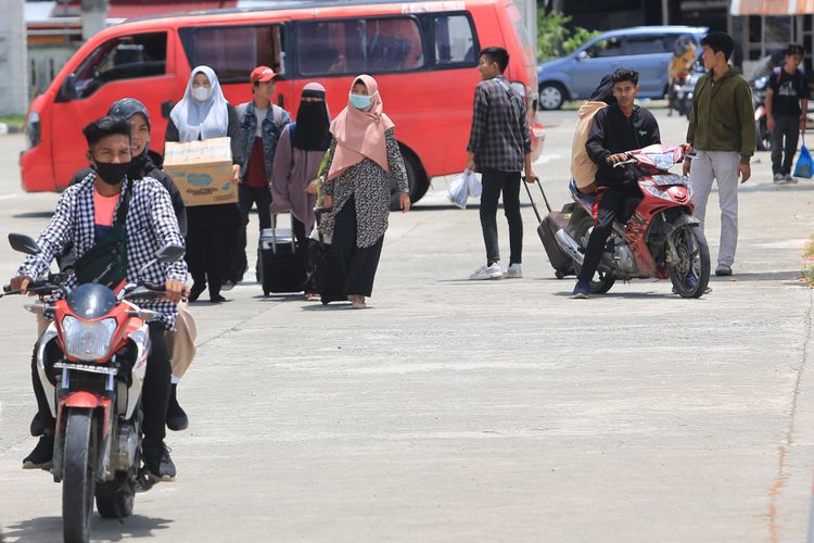 Sejumlah calon penumpang berjalan dan bersiap memasuki Kapal Motor Penyeberangan (KMP) Teluk Sinabang di Pelabuhan Penyeberangan Meulaboh-Sinabang Desa Gampong Teungoh, Samatiga, Aceh Barat, Aceh, Minggu (17/4/2022). Sebagian pemudik yang didominasi mahasiswa dan pedagang itu memilih mudik lebih awal untuk menghindari lonjakan dan kepadatan penumpang pada puncak arus mudik lebaran 2022.