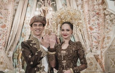 Enzy Storia dan Maulana Kasetra berada di atas pelaminan mengenakan baju adat.