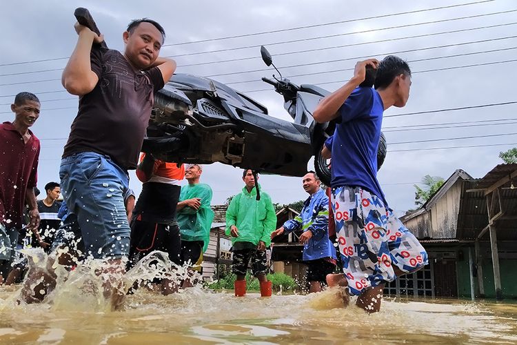 Warga membantu mengangkat sepeda motor milik korban banjir bandang di Desa Ameroro, Kabupaten Konawe, Sulawesi Tenggara, Minggu (9/6/2019). Pihak BPBD Provinsi Sulawesi Tenggara mencatat ada 7 kabupaten yang terdampak banjir bandang pasca hujan akibat meluapnya Sungai Konaweha dan Sungai Lasolo yang disebabkan alih fungsi lahan hutan menjadi perkebunan kelapa sawit dan penambangan nikel.