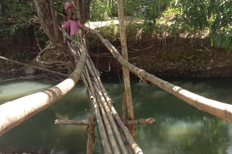 Suasana warga Jojjolo, Kecamatan Bulukumpa, Kabupaten Bulukumba, Sulawesi Selatan, melewati jembatan bambu. 