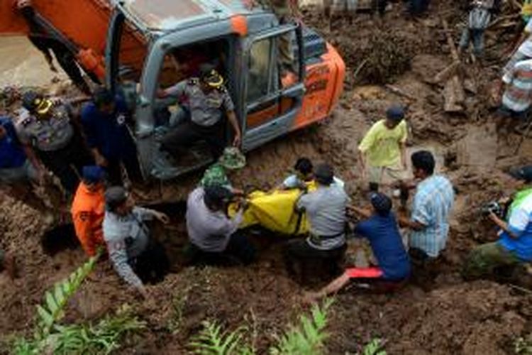 EVAKUASI KORBAN LONGSOR -- Sejumlah aparat gabungan dan ratusan warga melakukan dan menyaksian pencarian korban tanah longsor di Dusun Kopen, Desa Ngrimbi, Kecamatan Bareng, Jombang, Selasa (28/1/2014). Petugas berhasil mengevakuasi 7 jenazah dari perkiraan 14 warga yang tertimbun longsoran. (SURYA/AHMAD ZAIMUL HAQ)