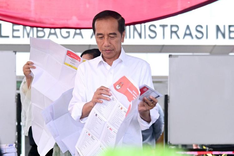 Presiden Joko Widodo memeriksa surat suara saat akan mencoblos di TPS 10 Gambir, Jakarta Pusat pada Rabu (14/2/2024).