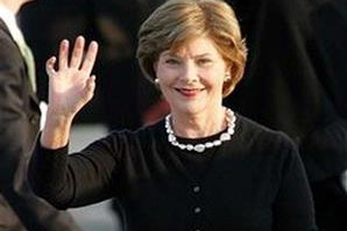 Laura Bush melambaikan tangan.