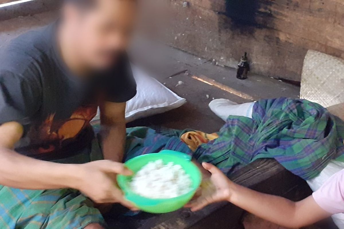 Yohana Grestiara Samur (7), sedang membawa makanan bagi ayahnya yang di pasung di bagian dapur di rumah orangtuanya di Kampung Waegerek, Desa Lidi, Kec. Ranamese, Kab. Manggarai Timur, Flores, NTT, Minggu, (17/11/2019). (KOMPAS.com/MARKUS MAKUR)