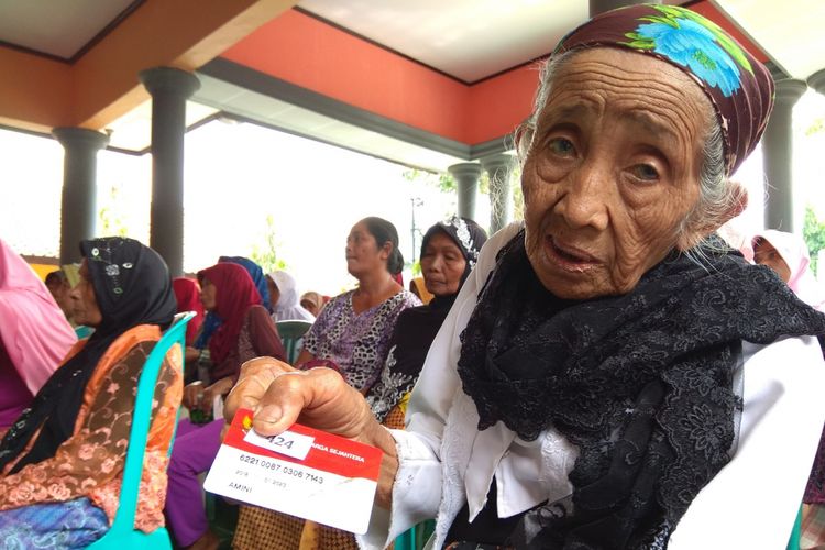 Mbah Amini, salah salah penerima bantuan pangan nontunai saat mengambil beras di Kantor Desa Kembiritan, Genteng, Banyuwangi, Senin (21/5/2018)