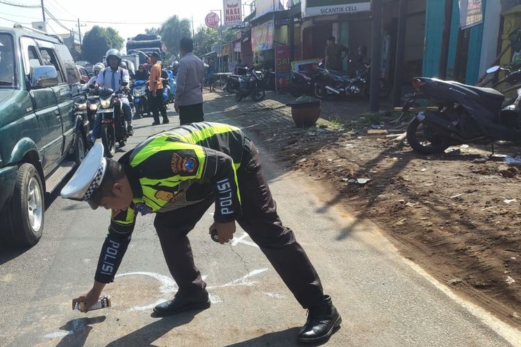 Anggota Satlantas Polres Malang saat melakukan olah TKP kecelakaan yang mengakibatkan ibu dan anak tewas di Desa Bululawang, Kecamatan Bululawang, Kabupaten Malang, Senin (2/6/2025).